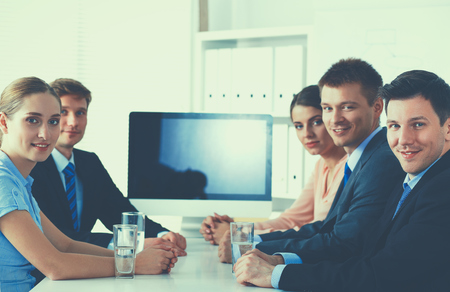 Business people sitting and discussing at meeting, in officeの写真素材