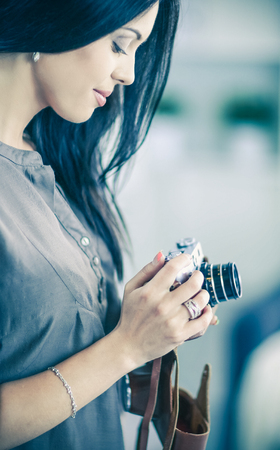 Female photographer sitting on the desk with laptopの写真素材