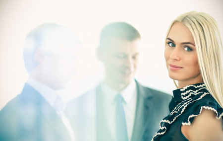 Business woman standing in foreground with a folder in her hands