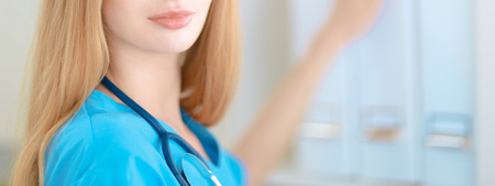 Doctor  woman is standing in the near windowの写真素材
