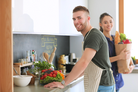 Couple cooking together in their kitchen at homeの写真素材