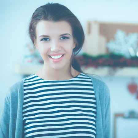Smiling young woman standing in the kitchenの写真素材