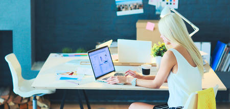 Fashion designers working in studio sitting on the deskの写真素材