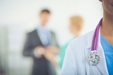 Woman doctor standing with stethoscope at hospitalの写真素材