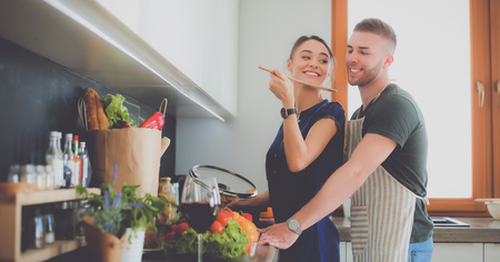 Couple cooking together in their kitchen at homeの写真素材