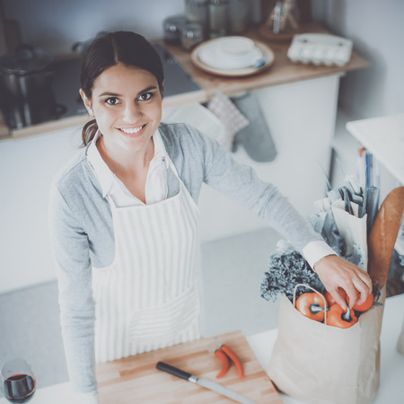 Woman making healthy food standing smiling in kitchenの写真素材