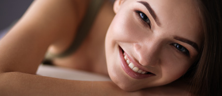 Closeup of a smiling young woman lying on couchの写真素材