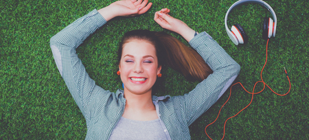 Relaxed woman  lying on the grass near headsetの写真素材