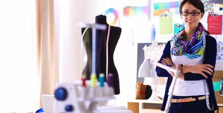 Beautiful fashion designer standing in studioの写真素材