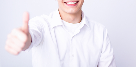 Happy man showing ok, isolated on gray backgroundの写真素材