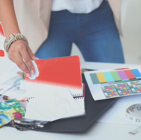 Smiling female fashion designer sitting at office deskの写真素材