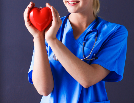 Doctor with stethoscope holding heartの写真素材