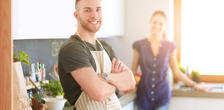 Couple cooking together in their kitchen at homeの写真素材