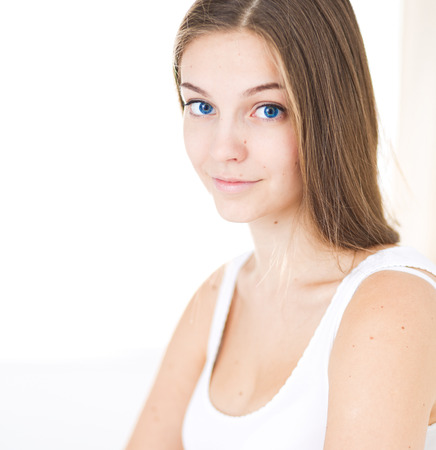 A pretty young woman sitting in bed.の写真素材