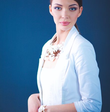 Portrait of young woman with beads, standing on gray backgroundの写真素材