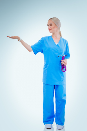 A portrait of a female doctor pointing, close-up, isolated on white background. Woman doctorの写真素材