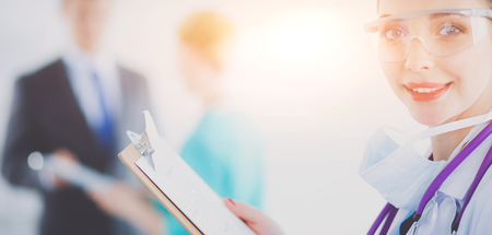 Woman doctor standing with folder at hospital. Woman doctorの写真素材
