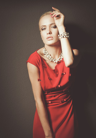 Portrait of young woman on red dress, isolated black backgroundの写真素材