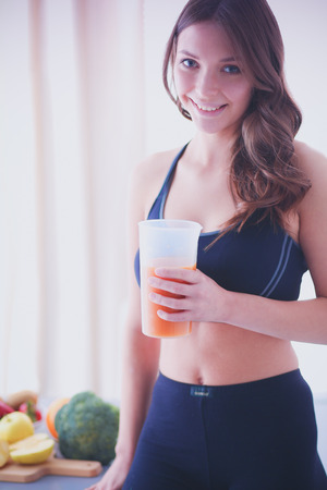 Portrait of a pretty woman holding glass with tasty juice.の写真素材