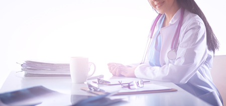 Female doctor sitting on the desk and working の写真素材