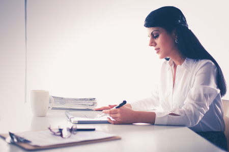 Woman with documents sitting on the deskの写真素材