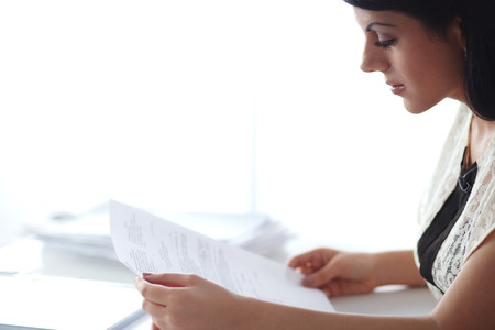 Woman with documents sitting on the deskの写真素材