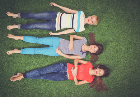 Young women lying on green grass . Young womenの写真素材