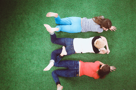 Young women lying on green grass . Young womenの写真素材