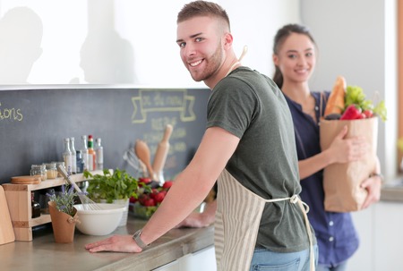 Couple cooking together in their kitchen at homeの写真素材