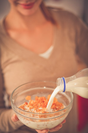 Smiling attractive woman having breakfast in kitchen interior. Smiling attractive woman.