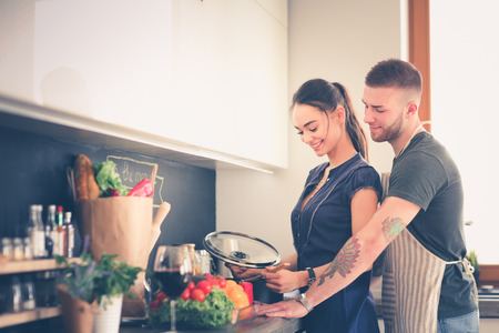 Couple cooking together in their kitchen at homeの写真素材