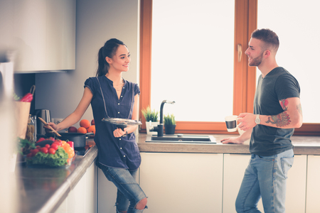 Couple cooking together in their kitchen at homeの写真素材