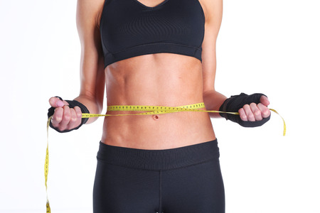 Fitness womans beautiful body with measure tapeの写真素材