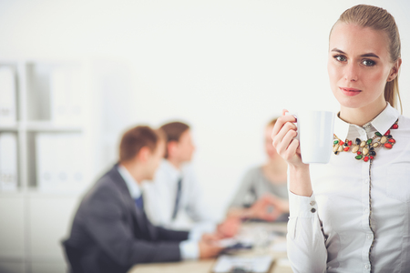 Portrait of a young woman working at office standing . Young womanの写真素材