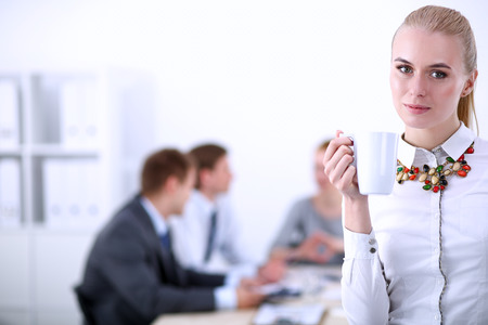 Portrait of a young woman working at office standing . Young womanの写真素材