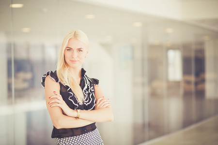 A beautiful blond business woman is talking on the phone.の写真素材