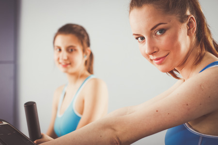 Group of people at the gym exercising on cross trainers. people at the gymの写真素材