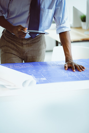African american architect working with computer and blueprints in officeの写真素材