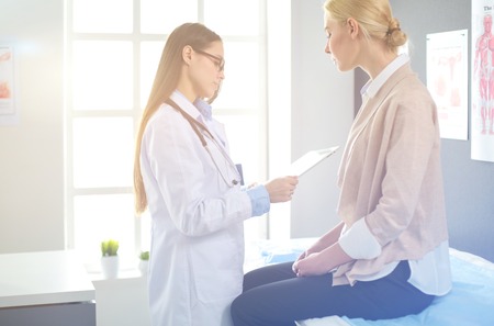 Doctor and patient discussing something while sitting at the table . Medicine and health care conceptの写真素材