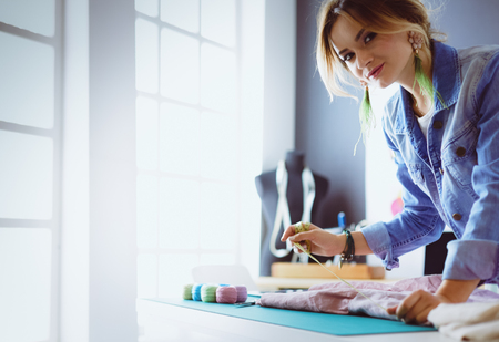 Fashion designer woman working on her designs in the studioの写真素材