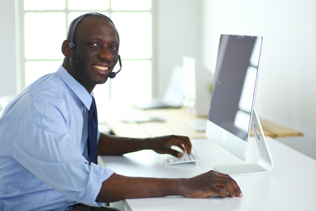 African american businessman on headset working on his laptopの写真素材