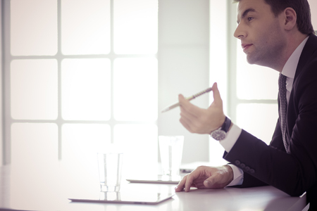 Portrait of young man sitting at his desk in the office.の写真素材