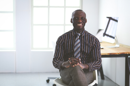 Portrait of an handsome black businessman sitting in officeの写真素材