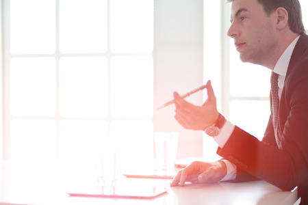 Portrait of young man sitting at his desk in the office.の写真素材