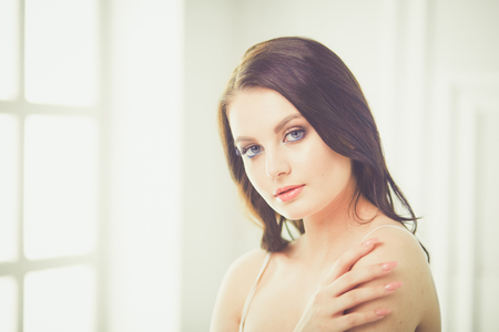 Beautiful brunette lying on bed at homeの写真素材