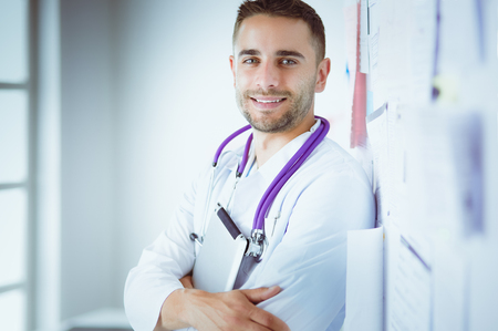 Young and confident male doctor portrait standing in medical officeの写真素材