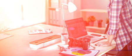 Female photographer sitting on the desk with laptop . Female photographer