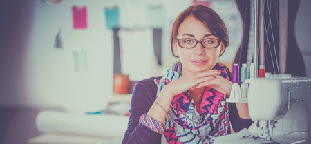 Beautiful fashion designer sitting at the desk in studioの写真素材