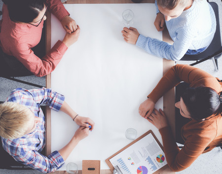 Business people sitting and discussing at meeting, in officeの写真素材