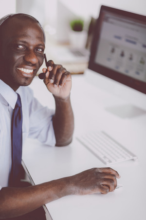 African american businessman on headset working on his laptopの写真素材